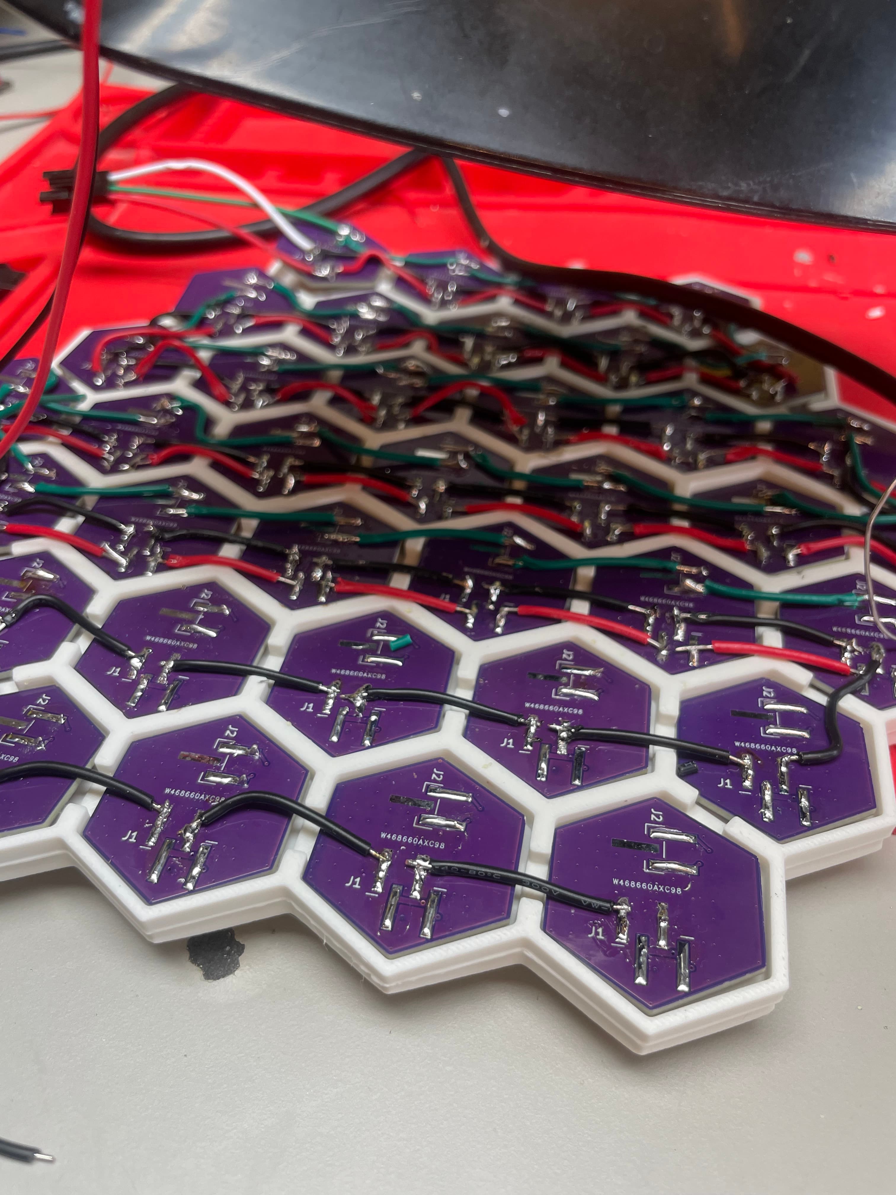 An array of small hexagonal Sol Spektrum PCBs wired together in a honeycomb assembly.